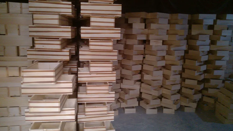 Assembled pine sliding lid wooden boxes stacked on the factory bench after glue-up