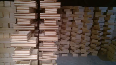 Assembled pine sliding lid wooden boxes stacked on the factory bench after glue-up