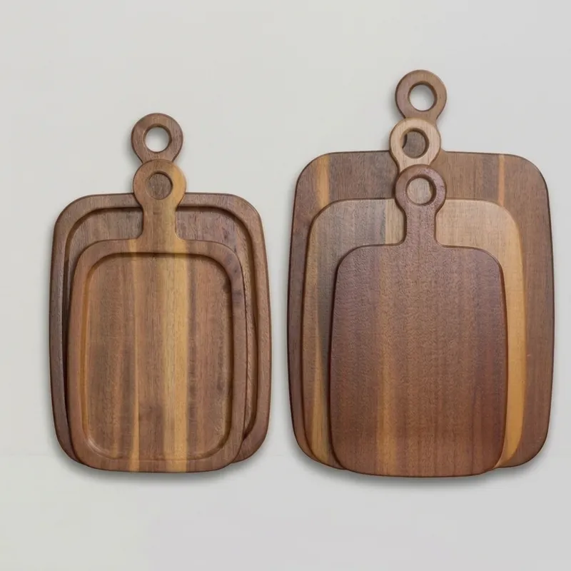 Two stacks of acacia wood cutting boards with round handles