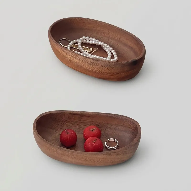 Small wooden valet trays filled with jewelry and mock berries