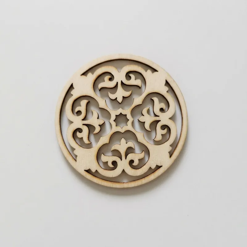 A laser cut wood medallion featuring a traditional symmetrical floral design.
