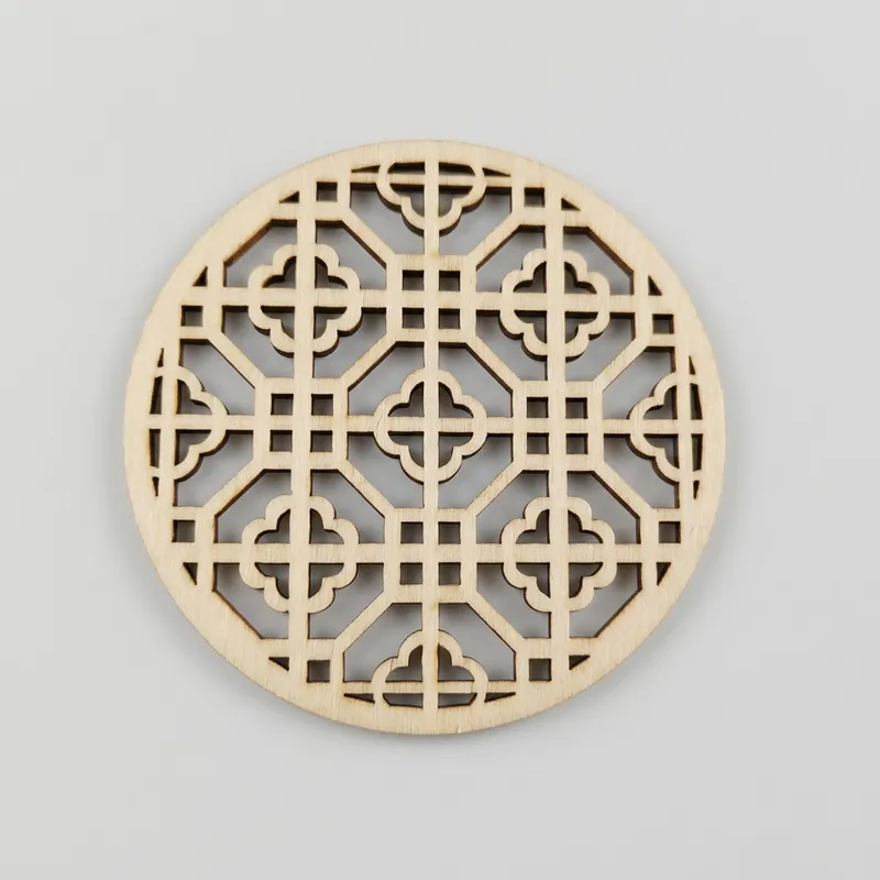 A round wooden piece featuring a square grid pattern with clover shapes.