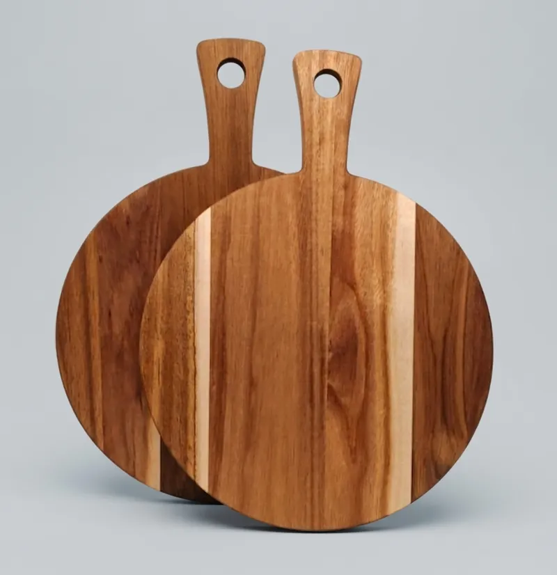 Two round acacia wood serving boards with integrated handles standing upright