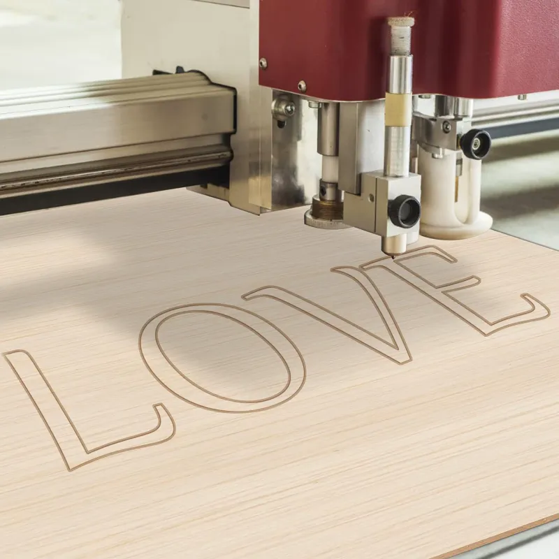 Laser engraving machine carving letters on a thin wood sheet