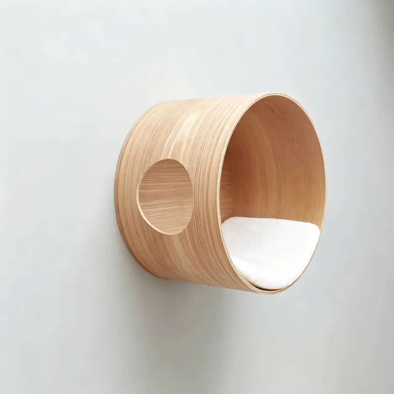 Angle view of a light-colored wooden cylindrical cat nest with side entry
